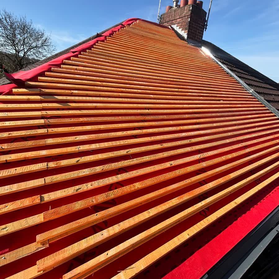 Hipped roof covered in new red breathable membrane with treated battens fixed across it