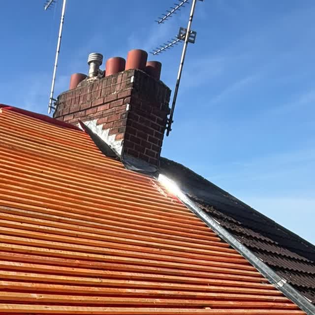 Brick chimney stack with lead flashing dressed in around the base of the stack